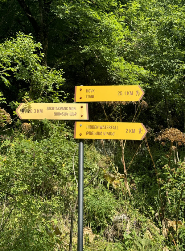 Trail signpost showing distances to Hovk, Gosh, and a hidden waterfall on the Armenia route