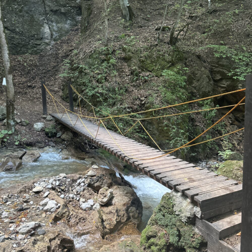 Wooden suspension footbridge crossing a rocky stream on the Armenia trek
