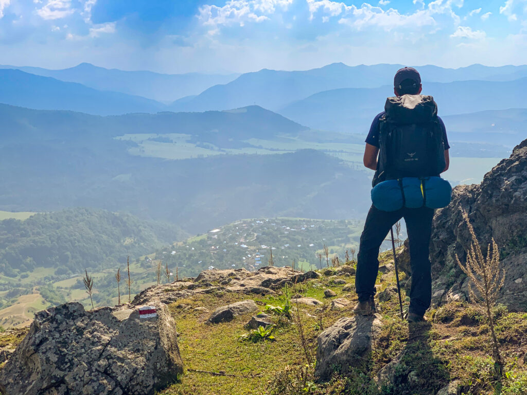 Hiker pausing at a trail waymarker overlooking the valley, Lori region, Armenia